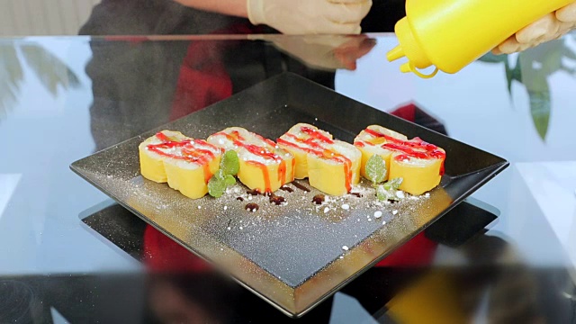 寿司放在黑色盘子里，用姜饼上的玫瑰装饰视频素材