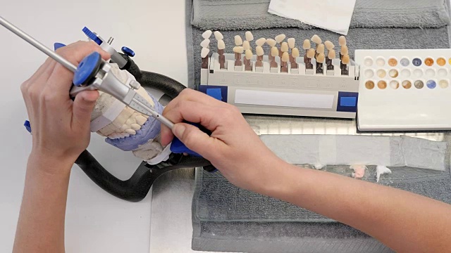 在牙科实验室的白色桌子上，将颌骨模型制成特殊的三脚架视频下载