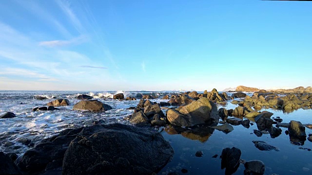 美丽的冬日里，挪威北部罗浮敦群岛Austvågsøya岛上，海浪拍打着岩石。视频素材
