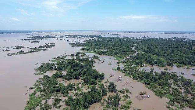 无人机拍摄:飞过被洪水淹没的湖面上的船屋和中国渔网视频下载