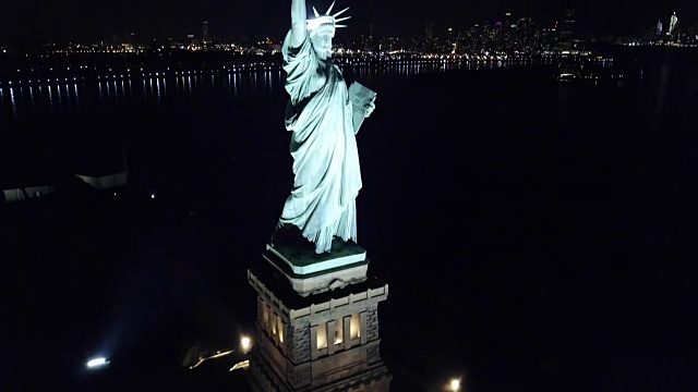 自由女神像国家纪念碑在纽约曼哈顿的夜晚点亮视频素材