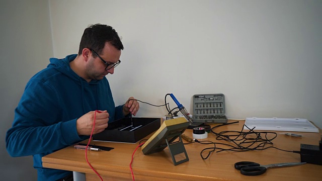 人测试电子设备，在家，在桌子上工作。视频素材