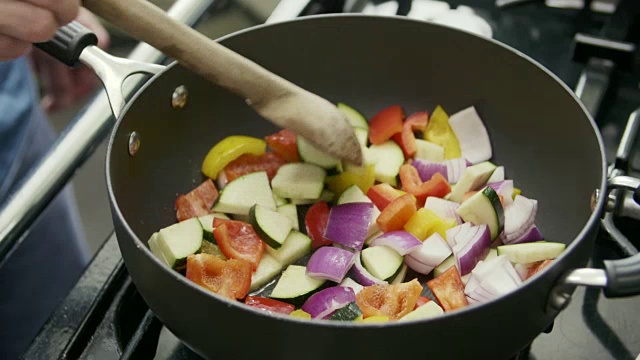 男用平底锅在炉子上炒健康蔬菜视频素材