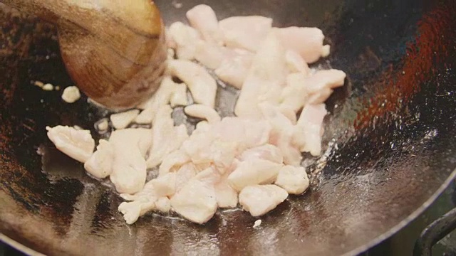 特写鸡肉是用勺子在锅里炒视频素材