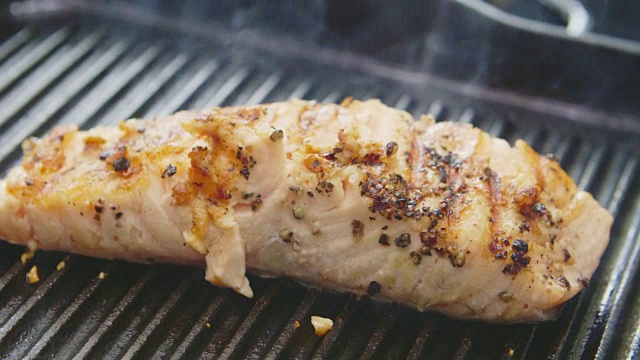 平底锅上的新鲜烤鱼吹出的蒸汽视频下载