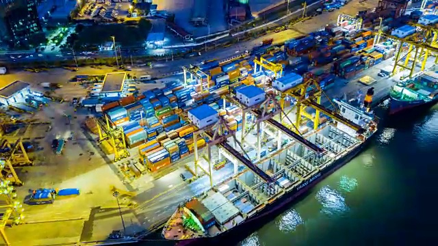 航拍东南亚工业港口与集装箱船在夜间的延时或延时视频素材