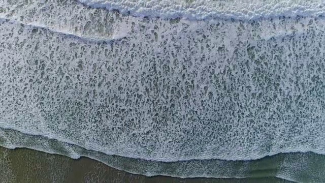 海浪冲向海滩海岸的航拍镜头视频下载