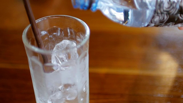 用手将饮用水倒入玻璃杯中视频素材