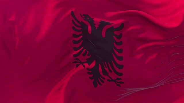 阿尔巴尼亚旗帜在慢动作经典旗帜平稳地吹在风在一个刮风的日子升起的太阳4k连续无缝循环背景视频下载