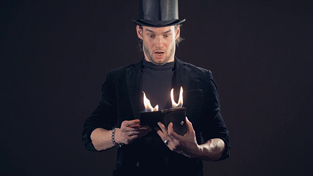 一个魔术师正在打开一个正在燃烧的钱包，并通过关闭它来呛火视频下载