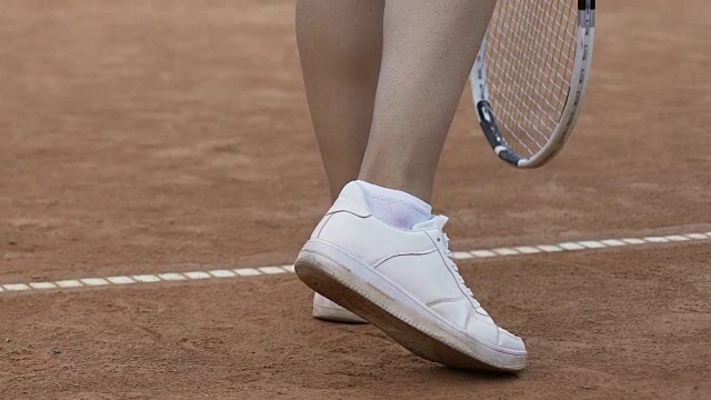 年轻女子与性感的腿打网球，发球在短裙，近视频下载