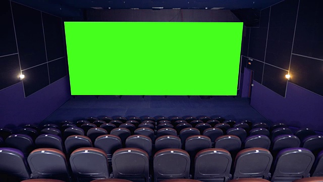 黑暗空旷的电影院大厅和绿色的屏幕。视频下载
