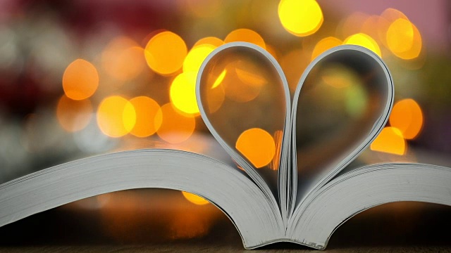 书页装饰成心形与庆祝散光的爱情和浪漫情人节的概念视频素材