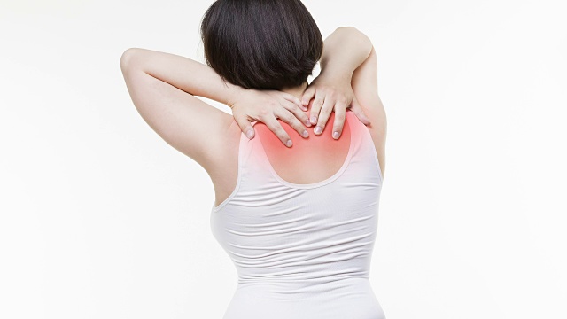 颈部疼痛，背部疼痛的女人在白色背景视频素材