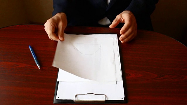 一个男人的手把一张白纸揉皱，扔在桌子上视频素材