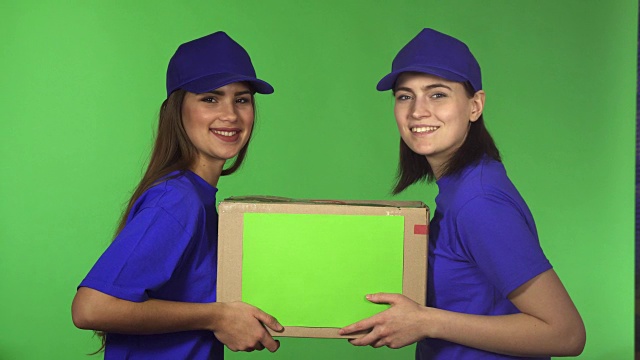 两名快乐的女快递员微笑着拿着纸板箱视频下载
