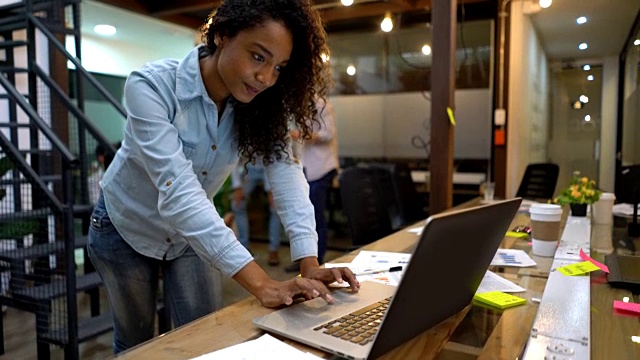 黑人女性创意工作在一个办公室看起来非常专注使用她的笔记本电脑视频素材