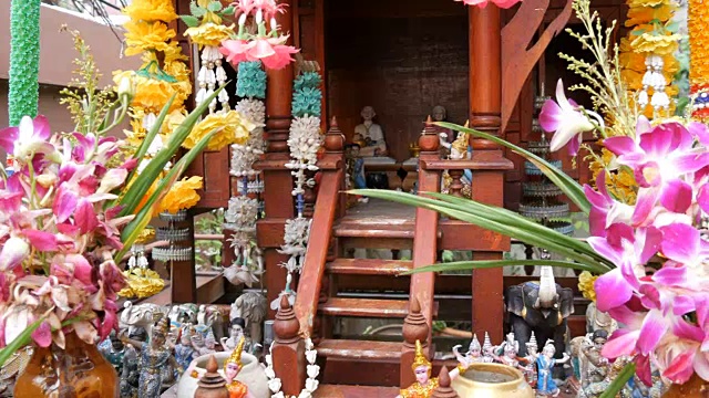 泰国园林中的传统佛坛装饰精美，有鲜花和各种象征人物视频下载