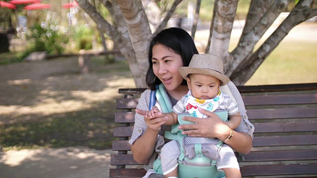 亚洲宝宝和妈妈坐在公园里视频素材