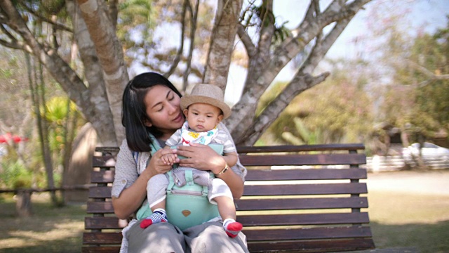 亚洲宝宝和妈妈坐在公园里视频素材
