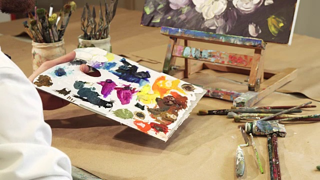 一个画家在调色板上挤油彩的特写镜头视频下载