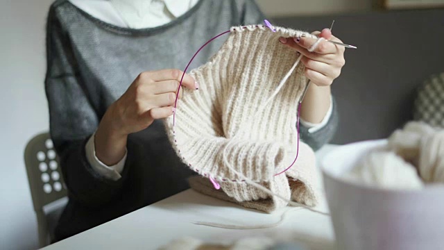 近距离女性的手编织针羊毛衣服。女人的爱好视频素材