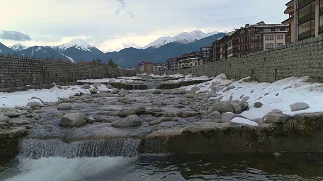 以皮林山脉为背景的慢镜头无人机低空飞过冬天的河流视频下载