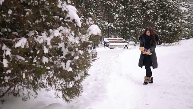 冬天在公园里散步的快乐孕妇。视频素材