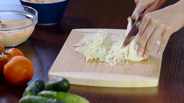 女性用手在木板上切白菜，特写，视频下载