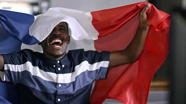 非洲人拿着法国国旗看电视比赛视频素材