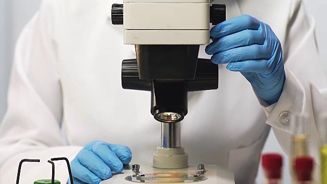 生物学家在显微镜下检查血液样本，寻找疫苗，特写视频素材