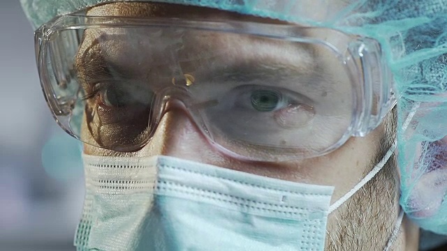 医学科学家戴着防护眼镜在实验室工作，特写视频素材