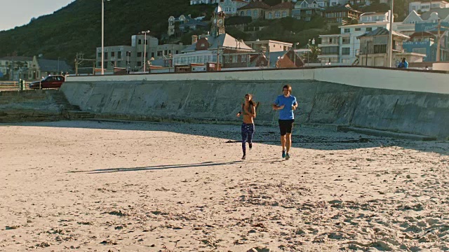一对健康的夫妇在海滩上跑步视频素材
