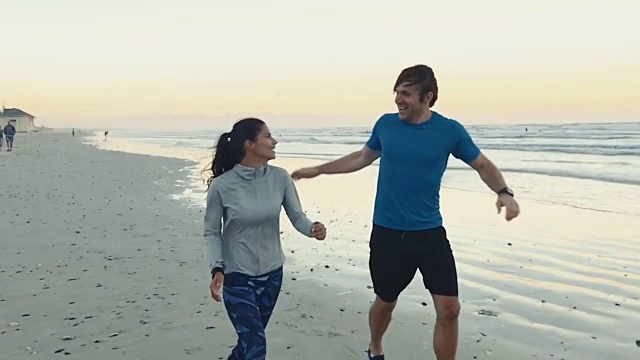 运动情侣在海滩上完成锻炼后击掌视频购买