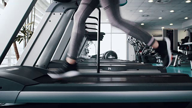 运动女性在跑步机上跑步视频下载