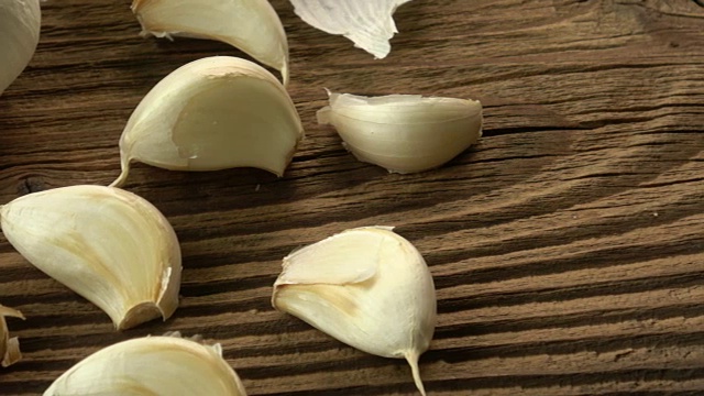 大蒜鳞茎。新鲜的大蒜放在木桌上。视频素材