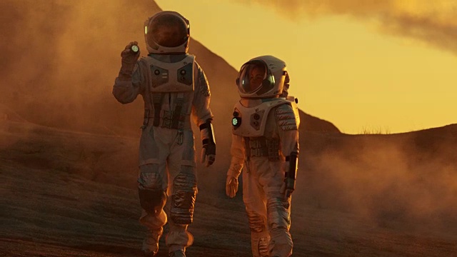 两名宇航员穿着太空服漫步探索火星/红色星球。太空旅行和太阳系殖民概念。视频下载