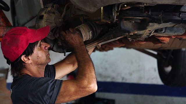 在汽车修理厂修理汽车的专业机械师视频素材
