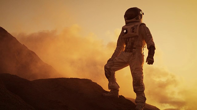 宇航员站在外星红色星球/火星的落基山的剪影。第一次载人火星任务。太空探索,殖民。视频素材
