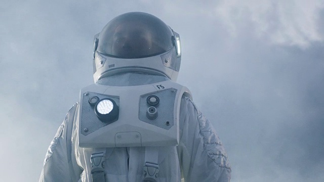 低角度拍摄的勇敢宇航员穿着宇航服环顾外星球。蓝色和寒冷的星球。先进技术，太空旅行，殖民概念。视频素材