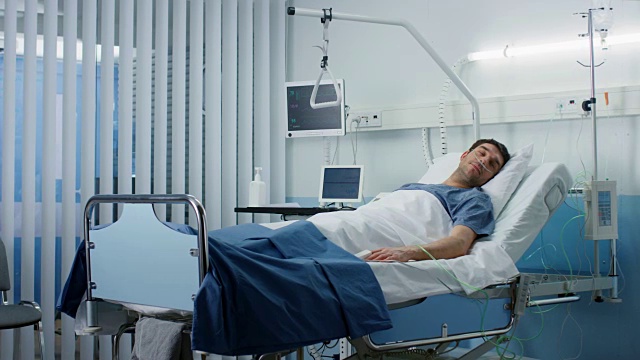 男病人躺在医院私人病房的病床上。白色,干净的环境。视频素材