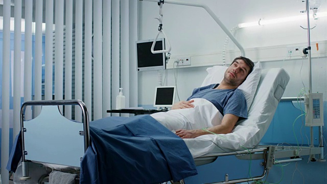 男病人躺在医院的病床上。干净平静的临床病房。视频素材