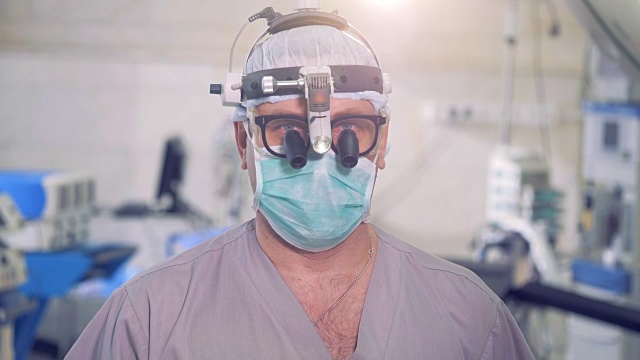 外科医生特写。医生用现代医疗设备看着相机。视频素材