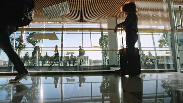 阳光透过大玻璃窗照射在机场候机楼里的乘客视频下载
