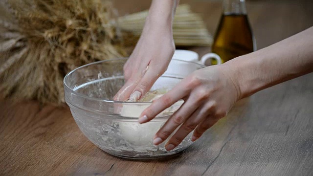 烹饪和家庭概念-女性的手在家里揉面的特写视频下载