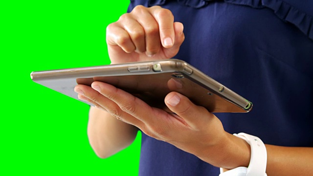 女性在绿色屏幕的4k下使用数码平板电脑视频素材