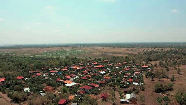 无人机拍摄:在旱季向后飞行，显示一个沉睡的村庄。视频素材