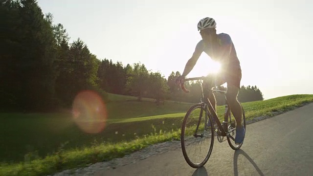 拷贝空间:职业男性公路自行车手享受阳光巡航他的自行车。视频素材