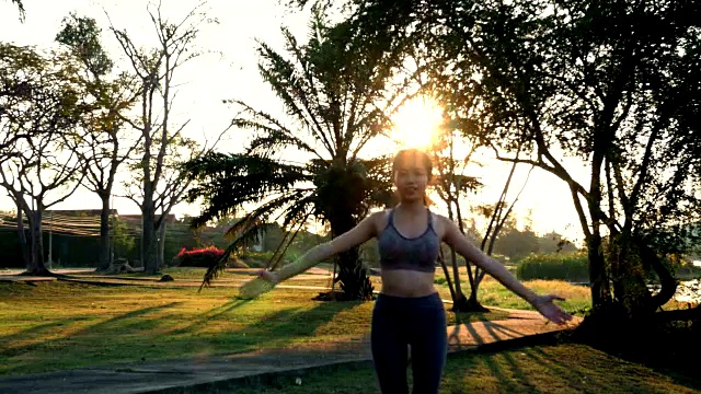 年轻女子锻炼，手臂伸出太阳耀斑视频素材