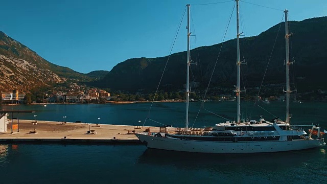 一艘大型游艇停泊在黑山科托尔湾的码头上。航拍镜头视频下载